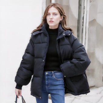 Giacca corta da donna in nero con cappuccio trapuntato. Di buona qualità e molto comoda, indossata da una donna.