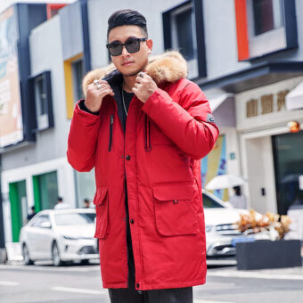 Uomo che indossa un piumino rosso con cappuccio di pelliccia, è in strada.