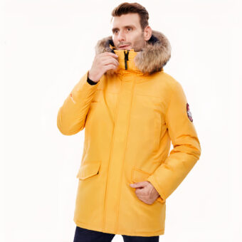 Uomo che indossa un piumino giallo con cappuccio su sfondo bianco.