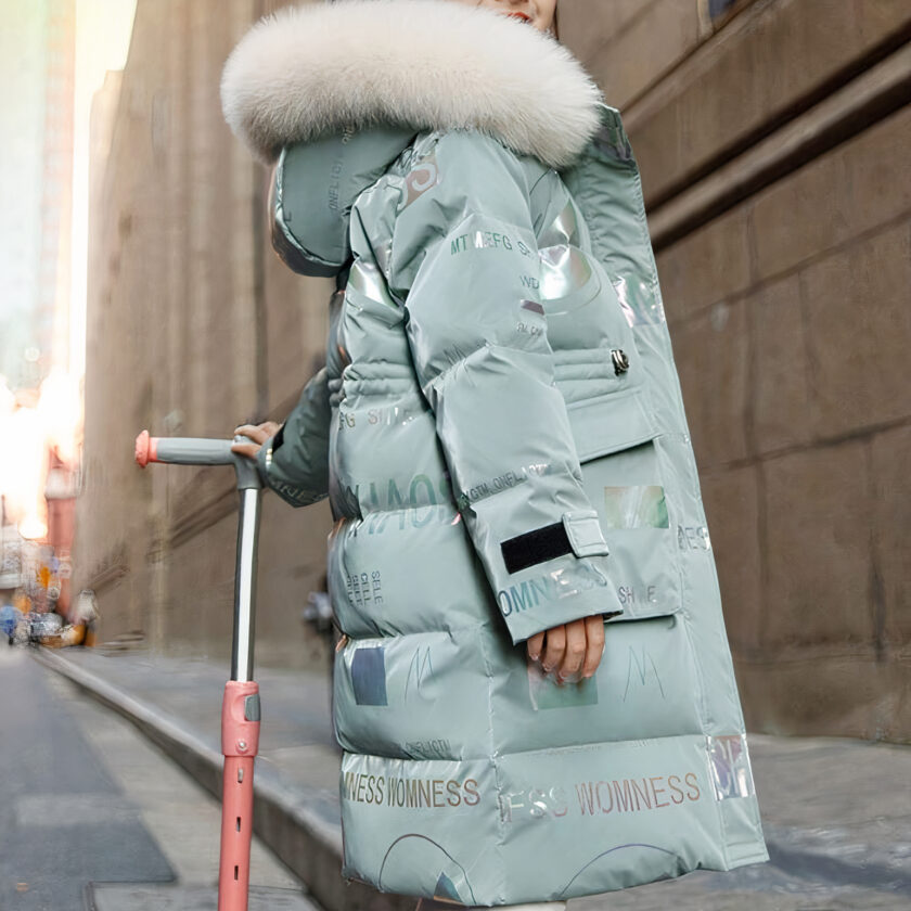 Ragazza adolescente in scooter per strada che indossa un piumino verde con cappuccio di pelliccia bianca.