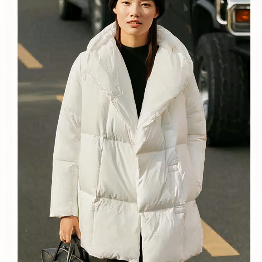Piumino bianco spesso da donna con cappuccio. Indossato da una donna, di buona qualità e molto alla moda.