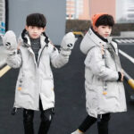 Ragazzo per strada che indossa un parka bianco con cappuccio.