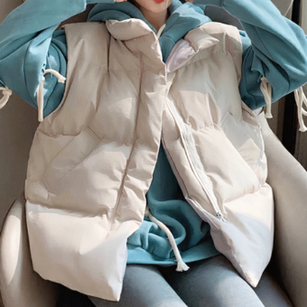 L'immagine è divisa in due e mostra la stessa giovane donna seduta che indossa una giacca premaman beige senza maniche su una felpa blu con cappuccio.