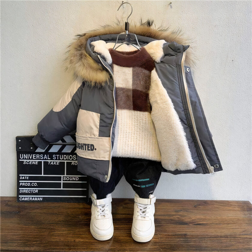 Una giacca di cotone caldo e spesso su un appendiabiti contro una parete grigia. Sul pavimento: parquet e scarpe bianche.