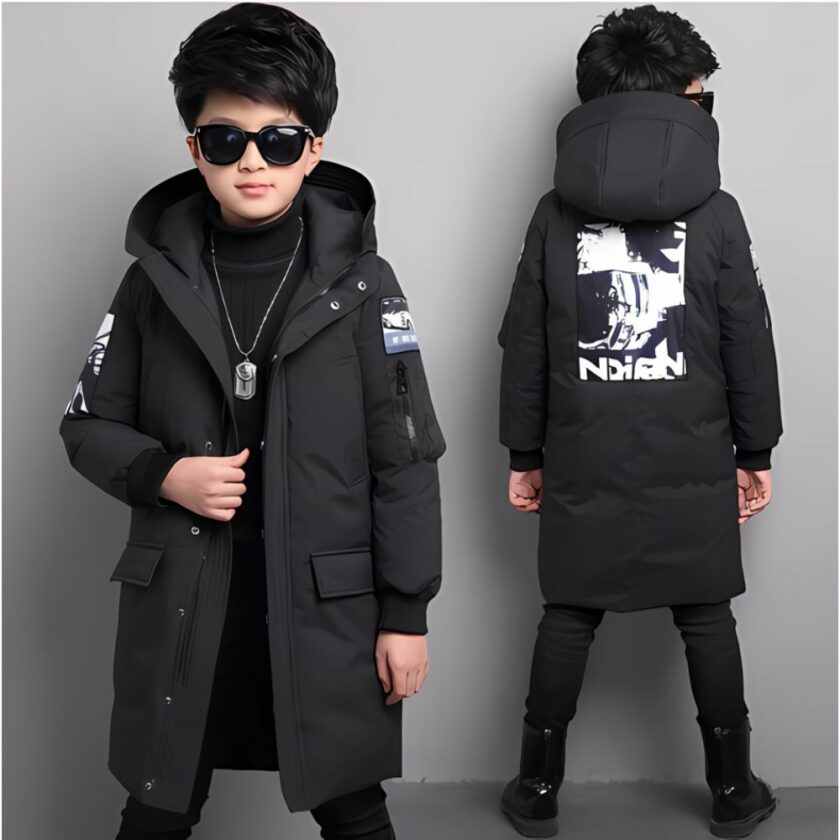 img_09_2024_veste_doudoune_longue_noire_capuche_garcon_1 Piumino lungo nero con cappuccio per ragazzi, indossato da un bambino con occhiali da sole e capelli neri. Di buona qualità e molto confortevole.