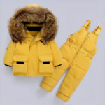 Piumino giallo per bambini su sfondo grigio.