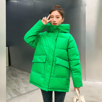 Giacca corta da donna di colore verde con ampie tasche anteriori.