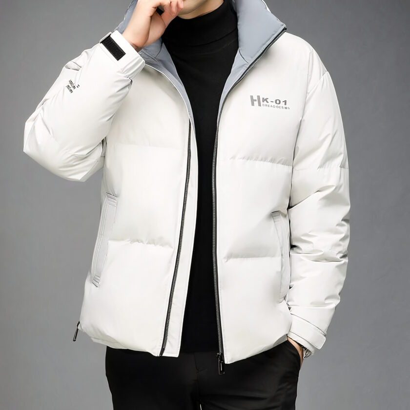 Foto di un uomo che indossa un piumino bianco aperto su uno sfondo grigio