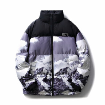 Su uno sfondo bianco, uno spesso piumino oversize con la parte superiore delle spalle in nero e il resto del busto e delle maniche con un cielo invernale e un paesaggio montano realistico in grigio, nero e bianco.