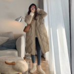 Foto di una donna che indossa un lungo piumino color kaki in un salone