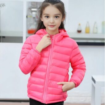 Bambina che indossa un sottile piumino con cappuccio per bambini in una stanza che sembra essere una cucina.