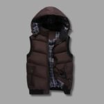 Giacca sportiva bicolore da uomo senza maniche, marrone scuro, con cappuccio annesso, fodera interna grigia in tartan, due tasche anteriori con zip, zip nera e bordi elasticizzati neri sui lati e sul fondo, vista frontale.