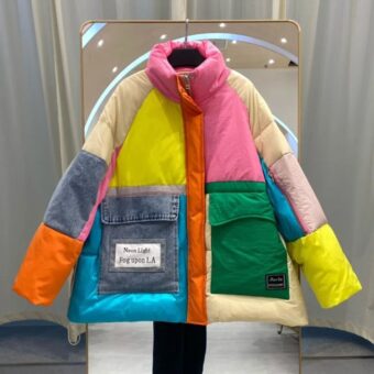 Piumino patchwork colorato appeso a una gruccia davanti a uno specchio.